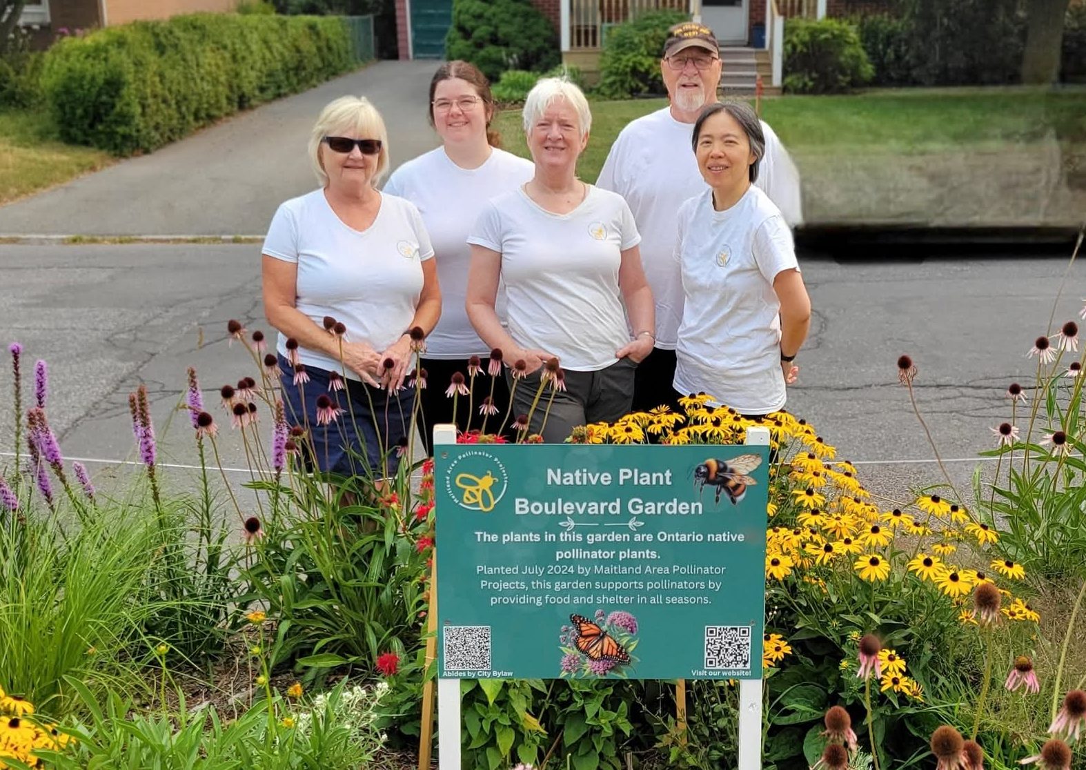 MAPP members. In the back, left to right are Karina and Harry. In the front left to right are Andrea, Pam, Grace. They all stand in a blooming garden. 
